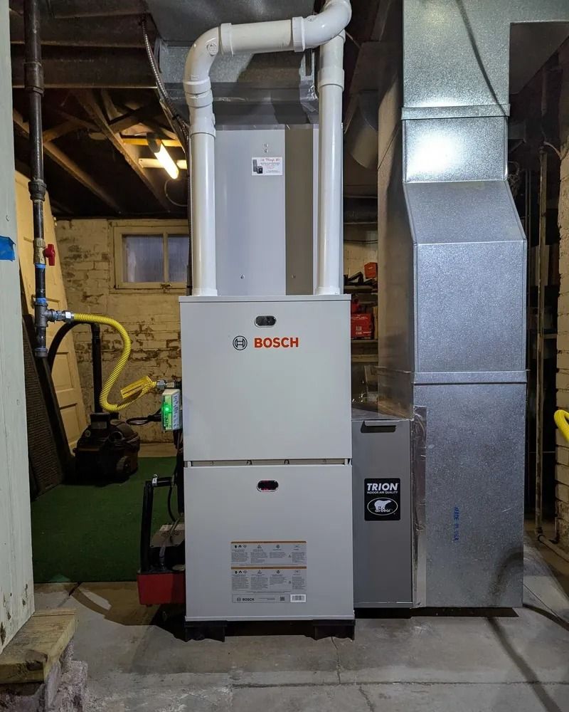 Bosch furnace beside silver ductwork in a basement utility room
