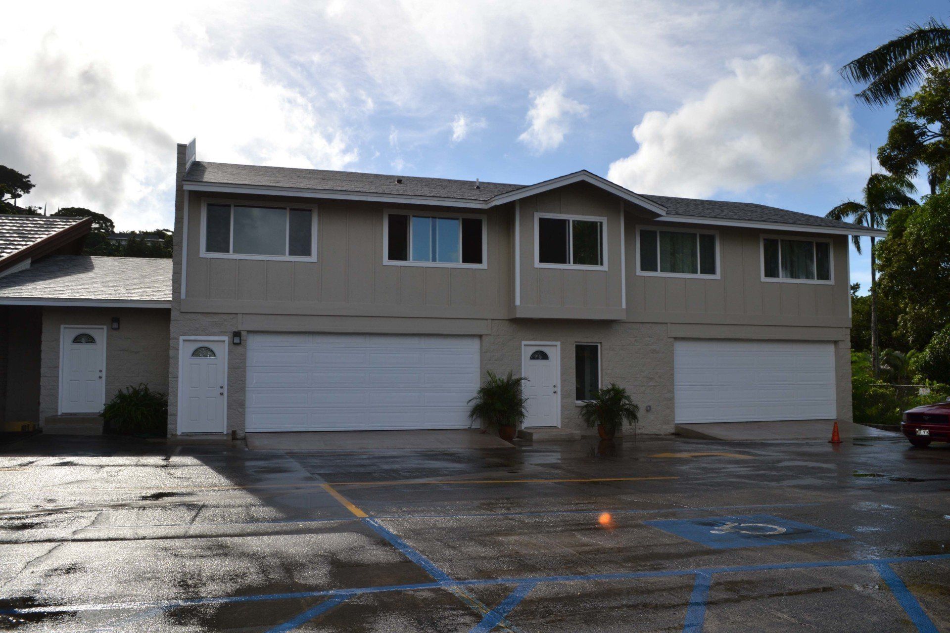 A house with a lot of garage doors and a car parked in front of it.
