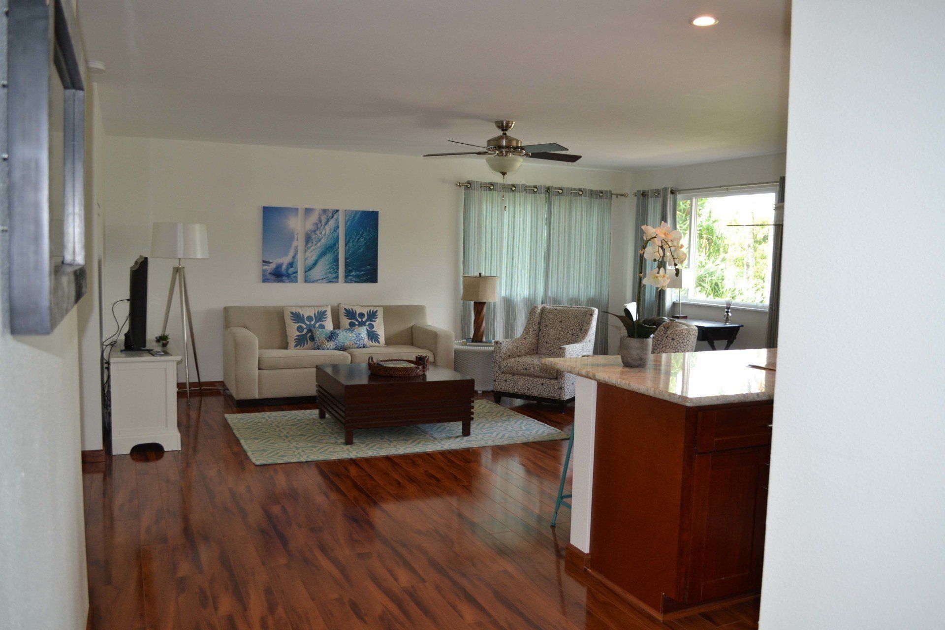 A living room with hardwood floors and a ceiling fan.