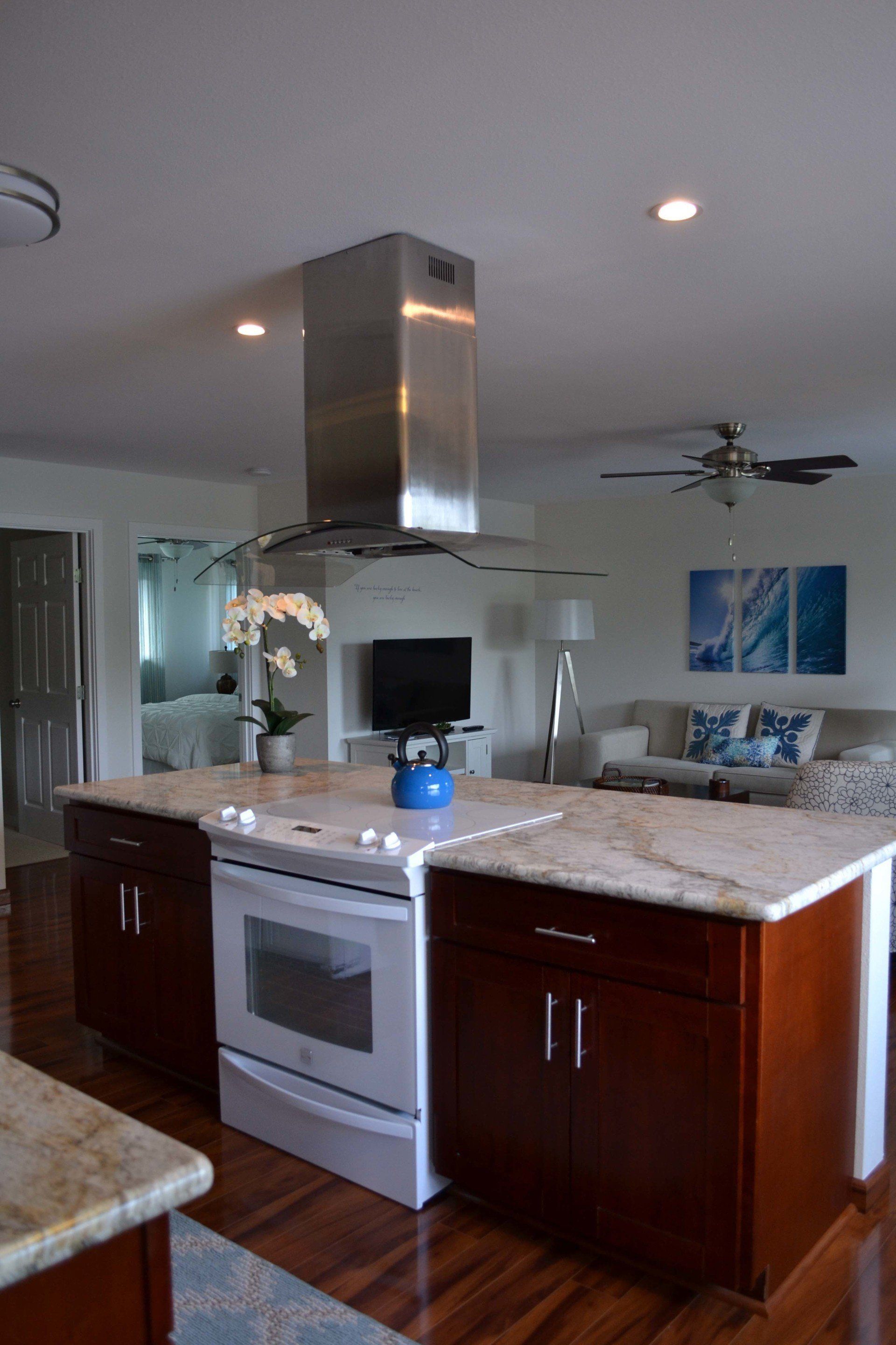 A kitchen with a large island and a stove top oven.