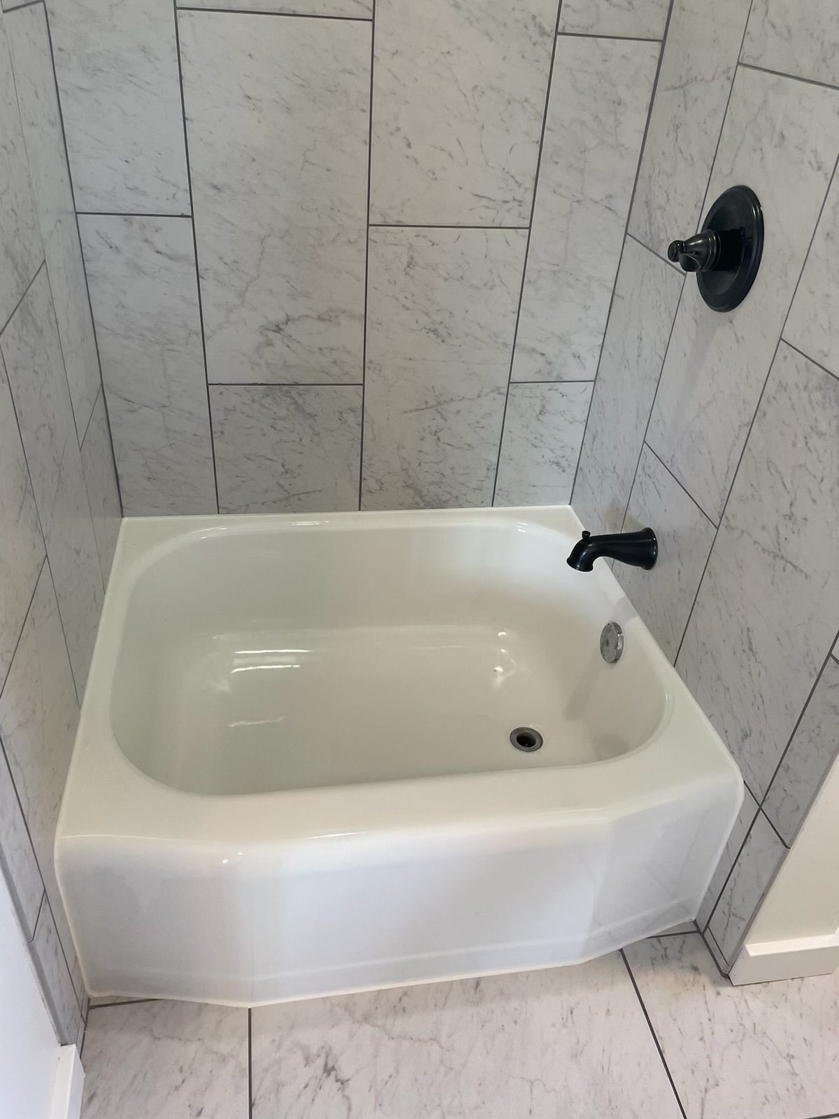 A white bathtub in a bathroom next to a shower.