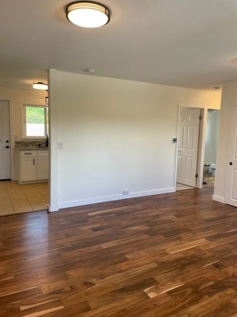 An empty room with hardwood floors and white walls.
