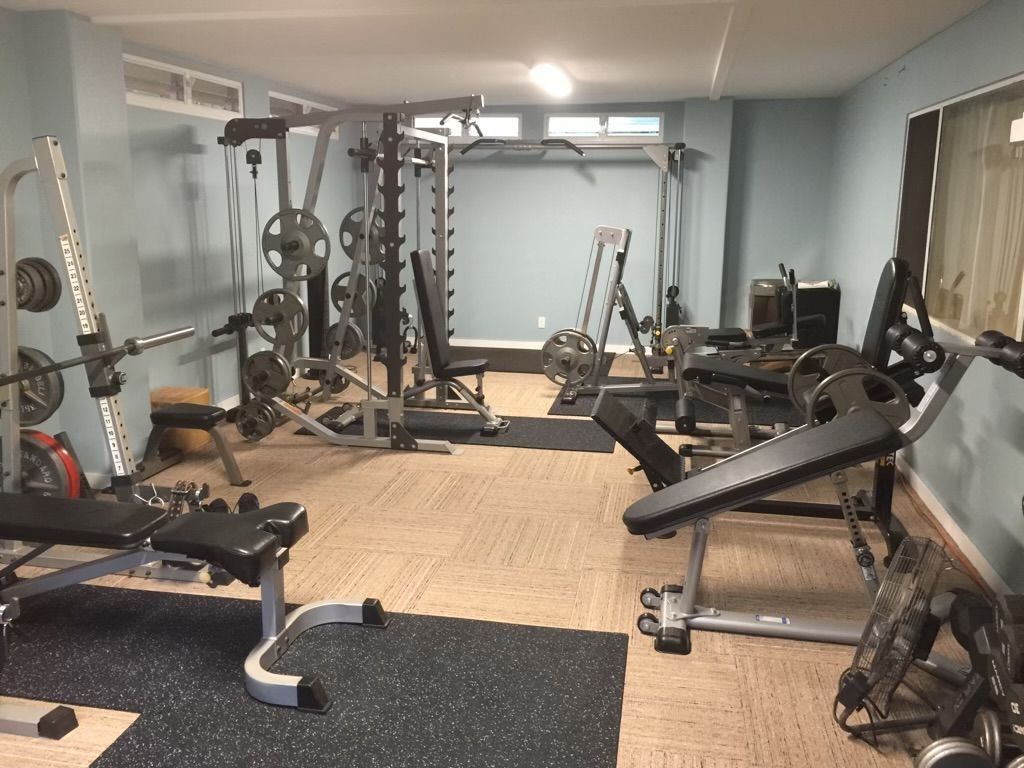 A large gym filled with lots of exercise equipment.