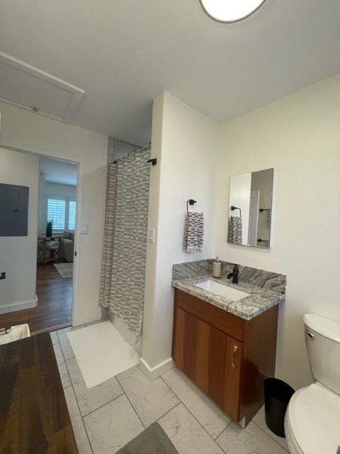 A bathroom with a toilet a sink and a mirror