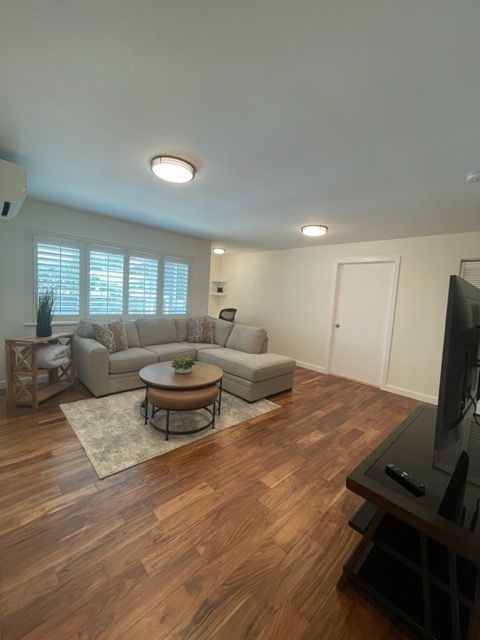 A living room with a couch , coffee table , and television.