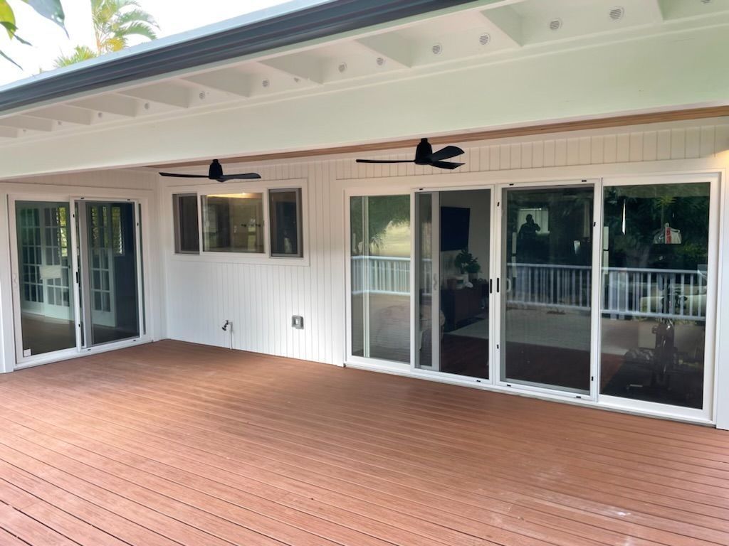 A large deck with sliding glass doors and ceiling fans