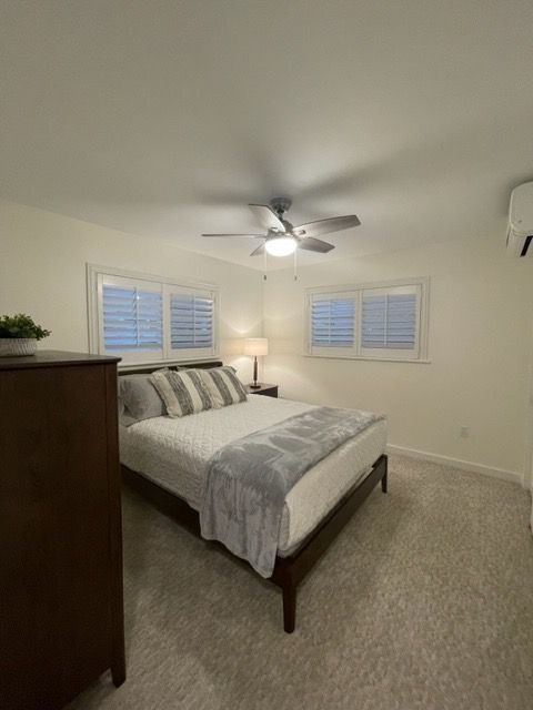 A bedroom with a bed , dresser , and ceiling fan.