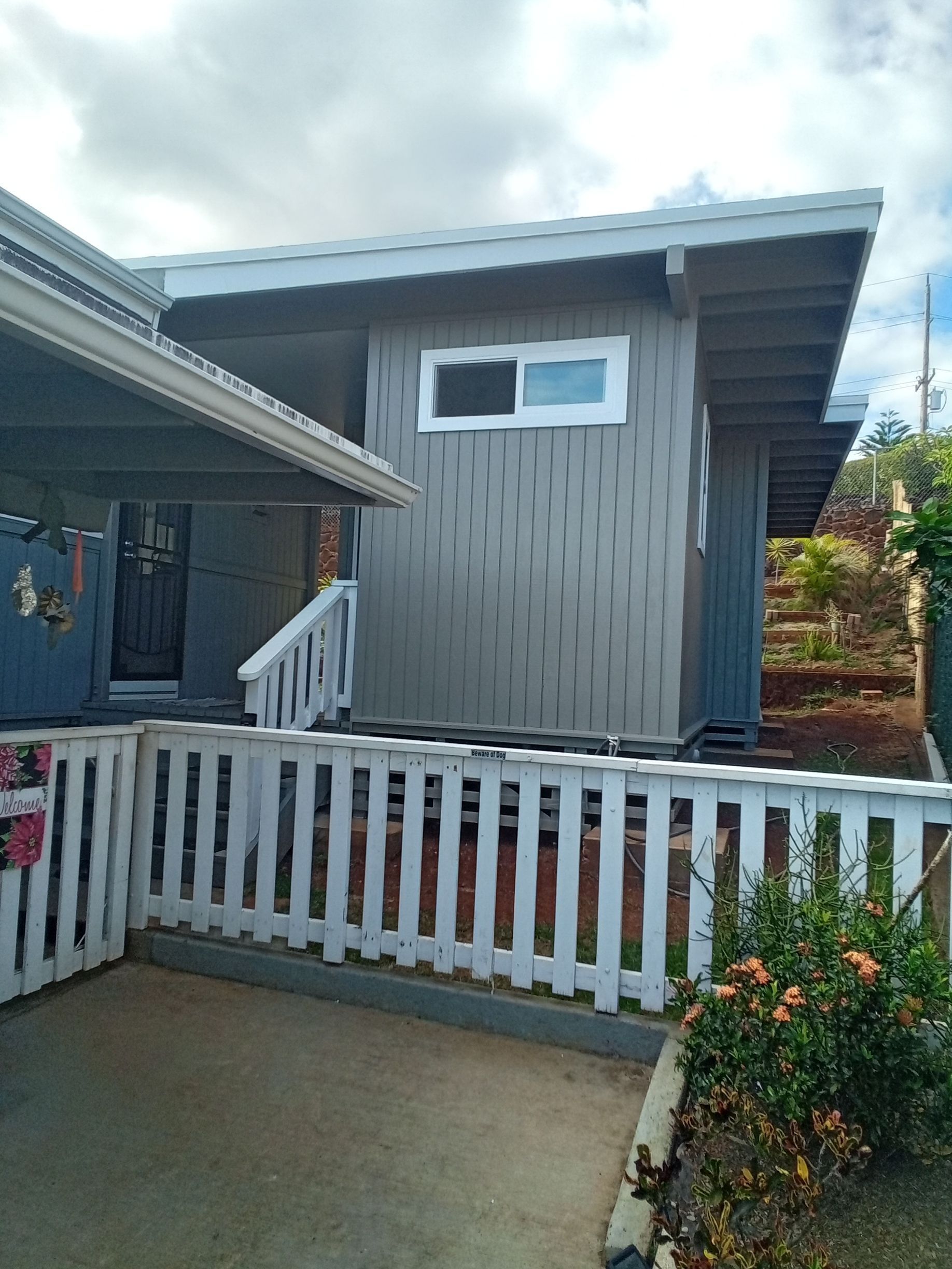 A small house with a white fence around it.
