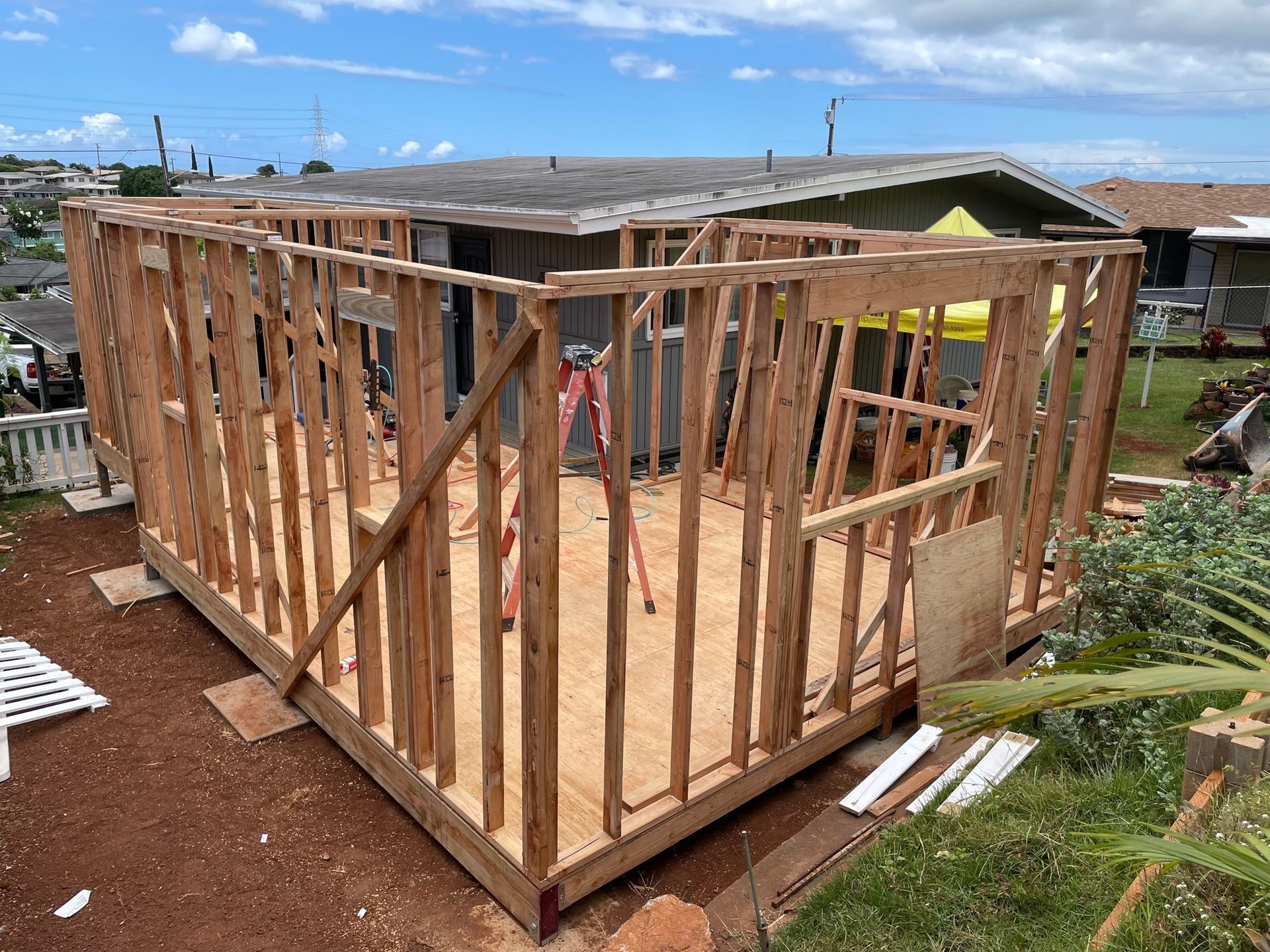 A wooden structure is being built in front of a house.