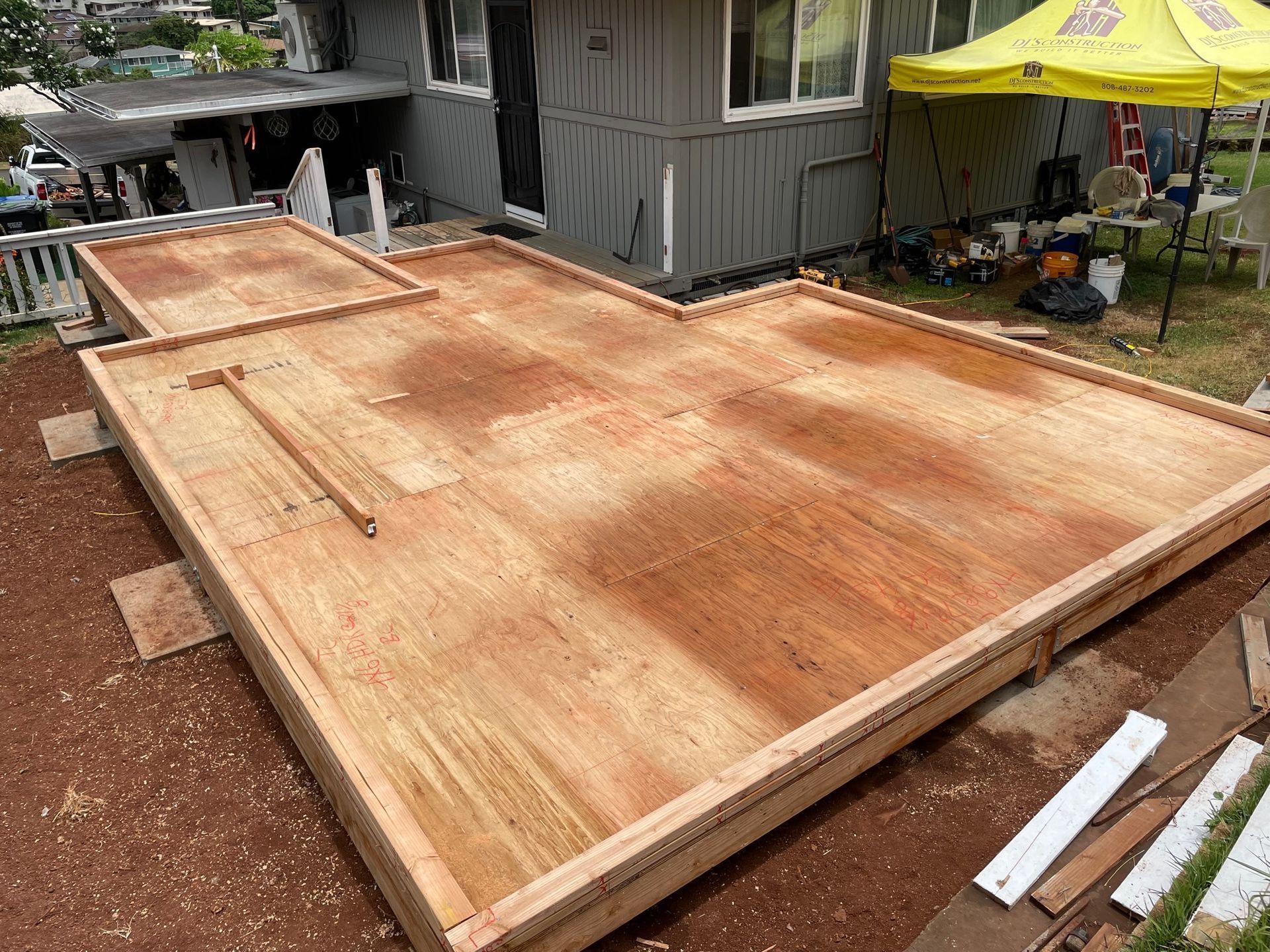 A wooden floor is being built in front of a house.