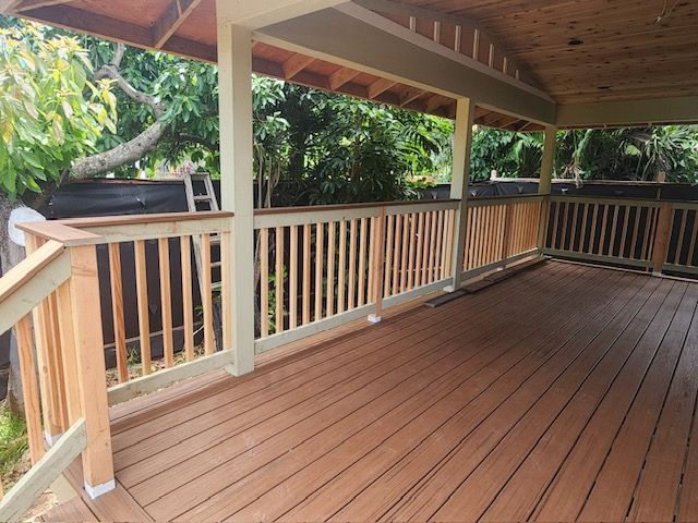 A wooden deck with a white railing and stairs