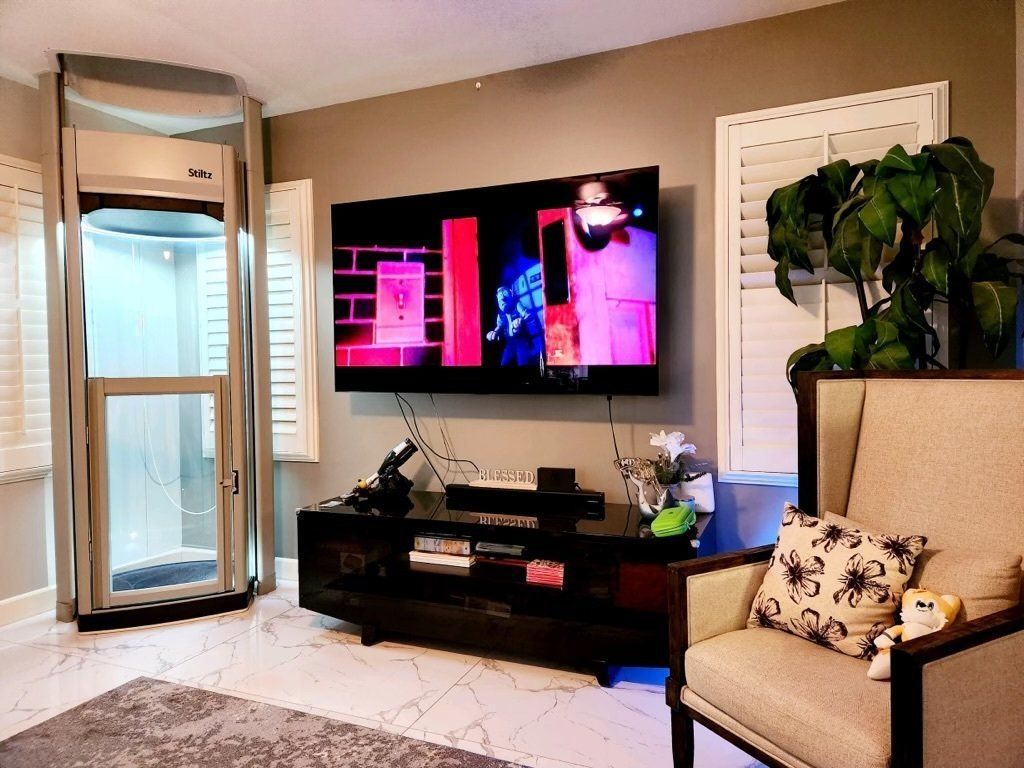 A living room with a chair , television , and elevator.