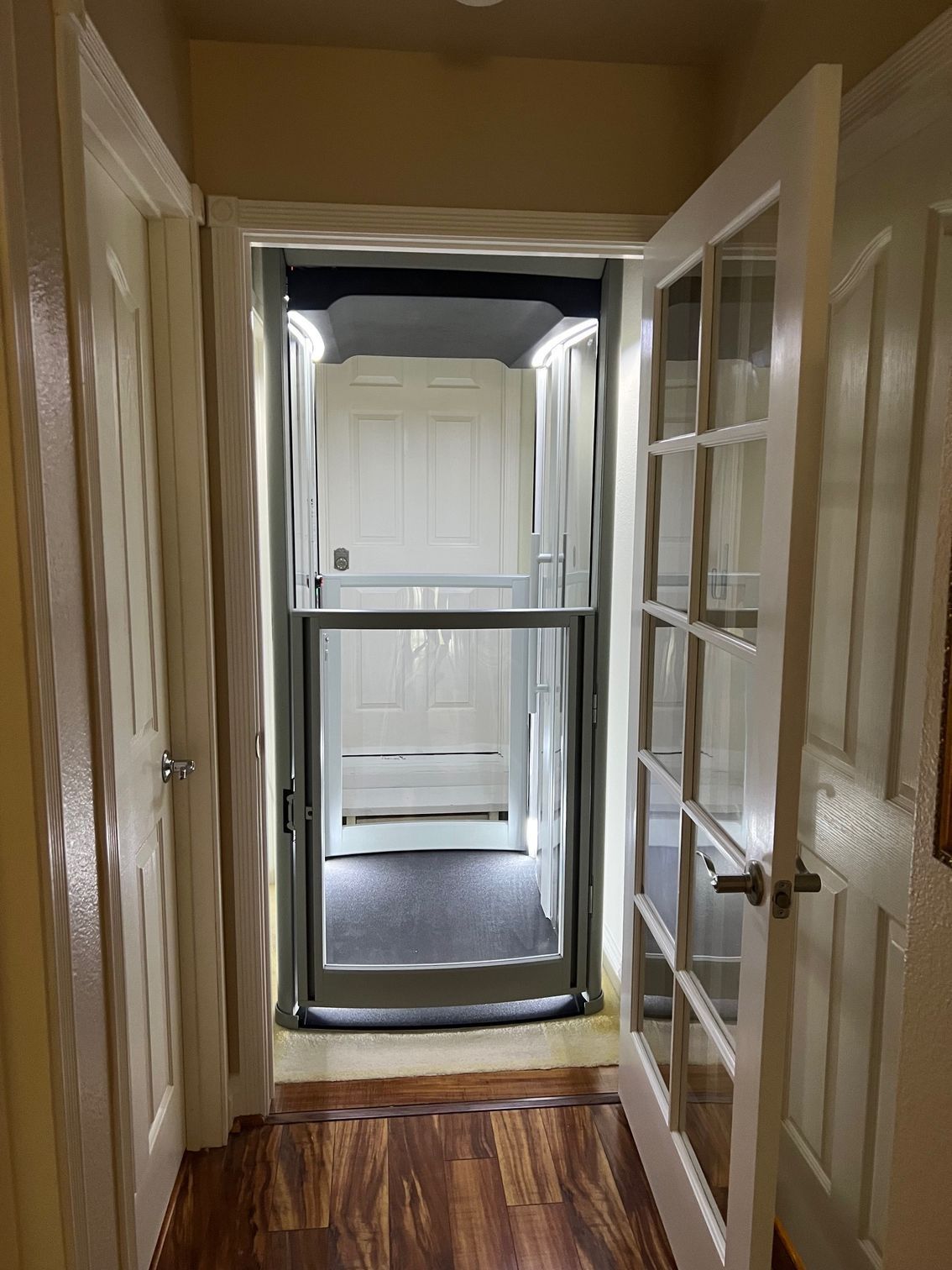 A hallway with a elevator between two doors.