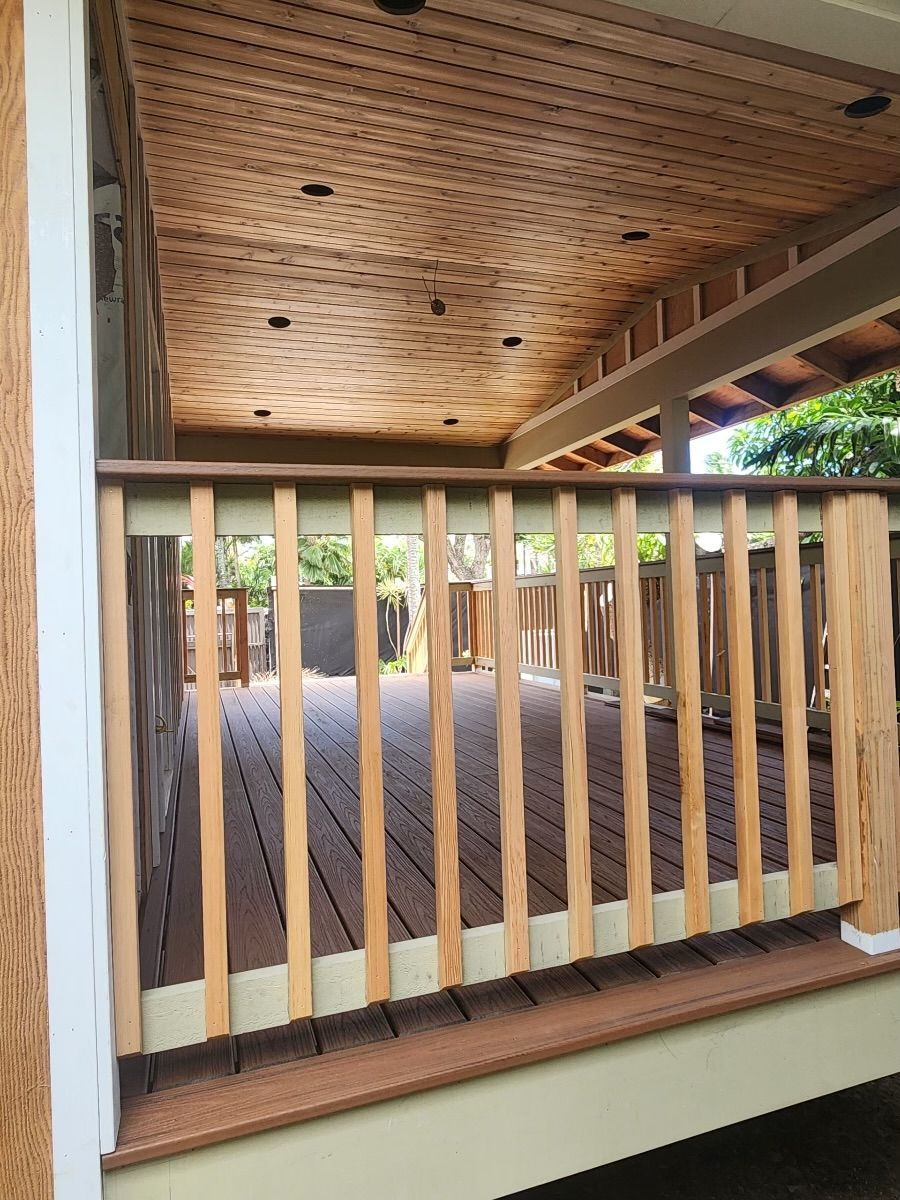 A wooden deck with a wooden railing and a wooden ceiling.