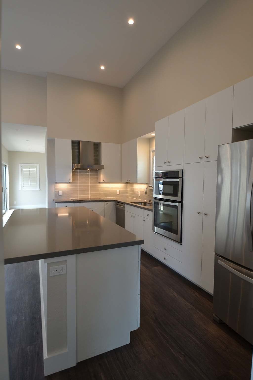 A kitchen with white cabinets and stainless steel appliances