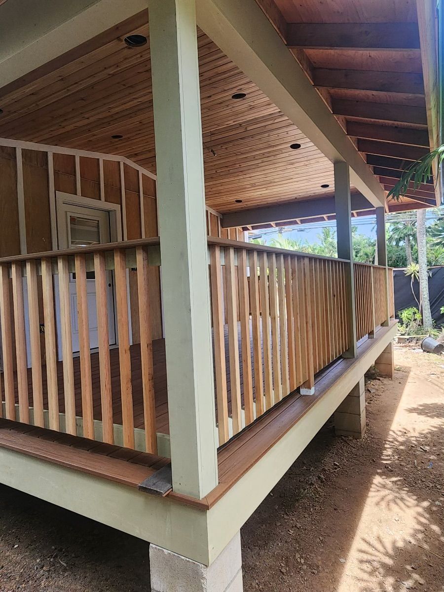 A porch with a wooden railing and a roof.
