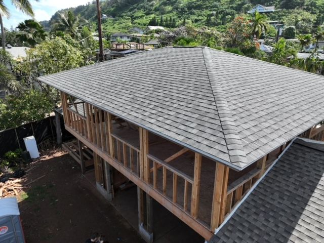 An aerial view of a house under construction with a roof