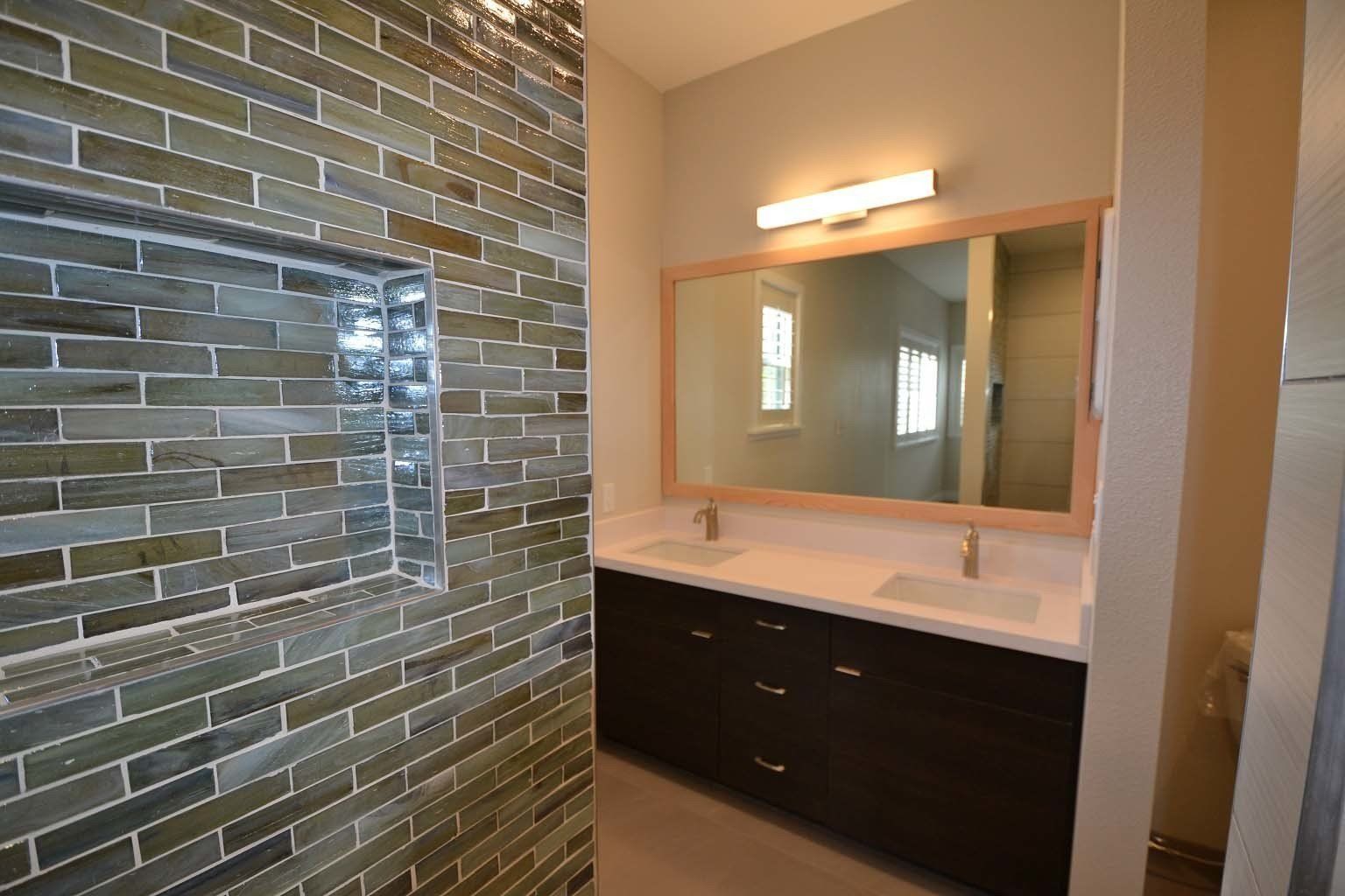 A bathroom with two sinks and a large mirror.