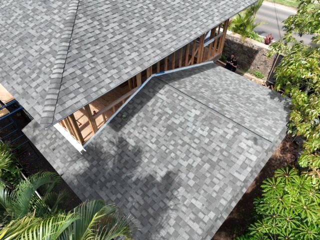 An aerial view of a house under construction with a gray roof.