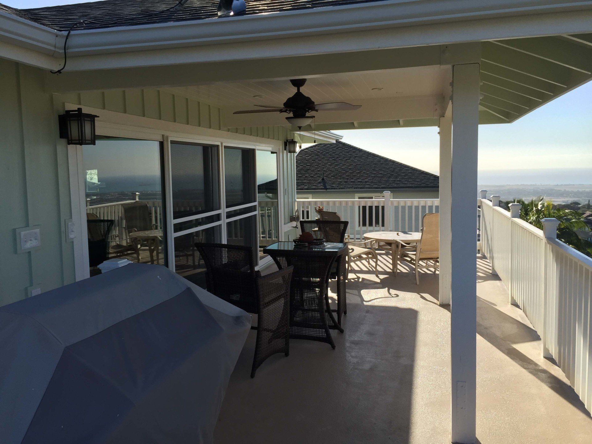A porch with a table and chairs and a ceiling fan