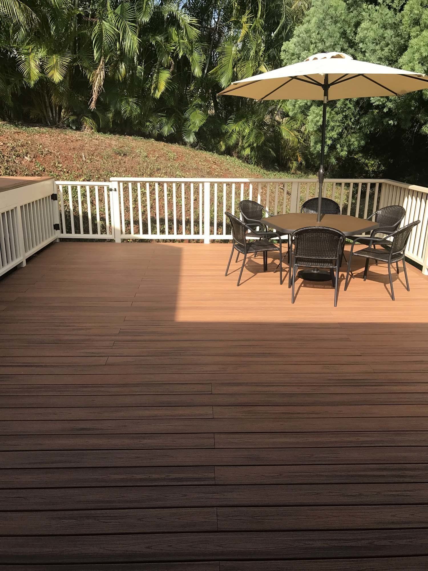 A wooden deck with a table and chairs and an umbrella.