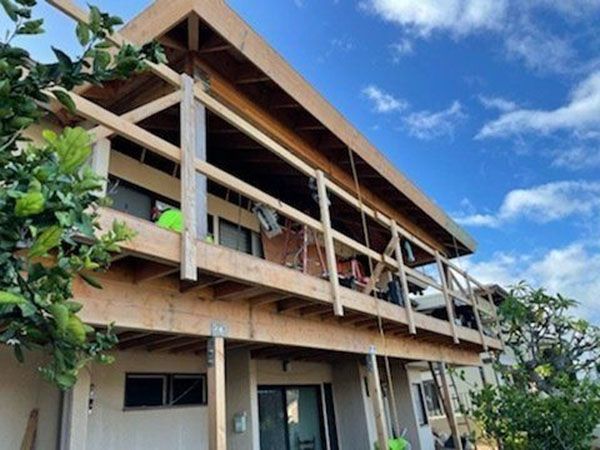 A house with a wooden deck and a blue sky in the background
