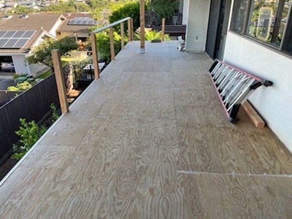 A ladder is sitting on top of a wooden deck.