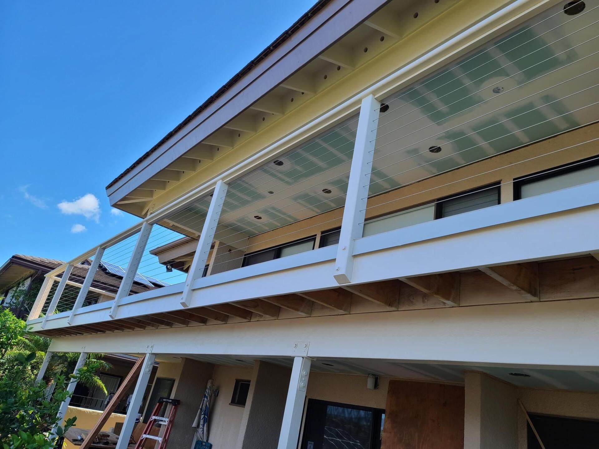 A house with a balcony and a blue sky in the background
