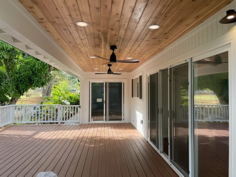 A large deck with a ceiling fan and sliding glass doors