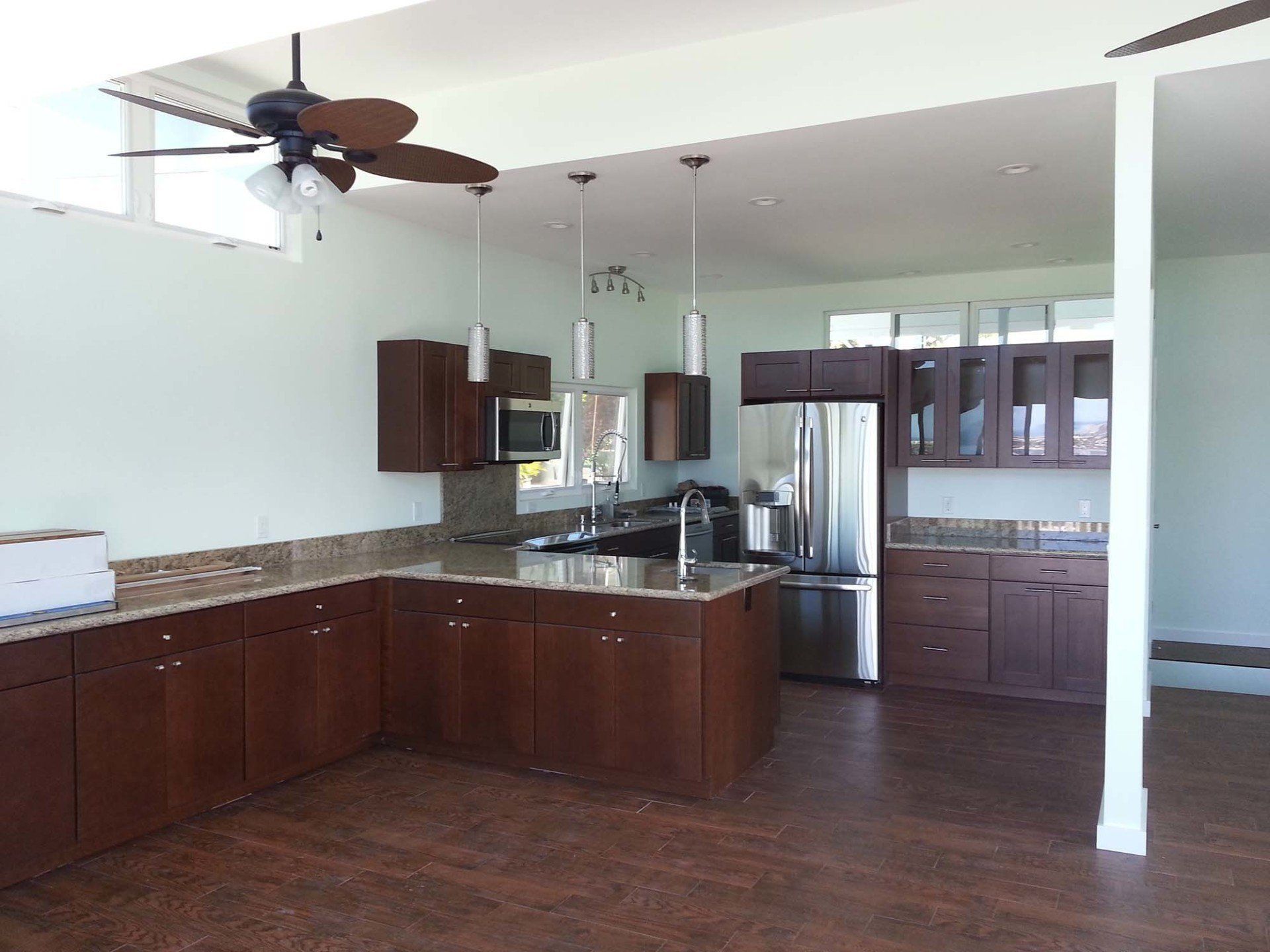 A kitchen with stainless steel appliances and a ceiling fan