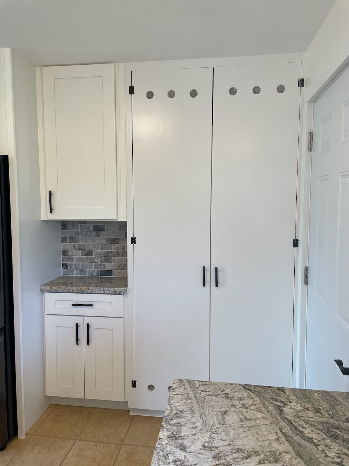 A kitchen with white cabinets and granite counter tops