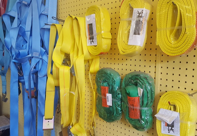 A bunch of yellow and blue straps are hanging on a wall.
