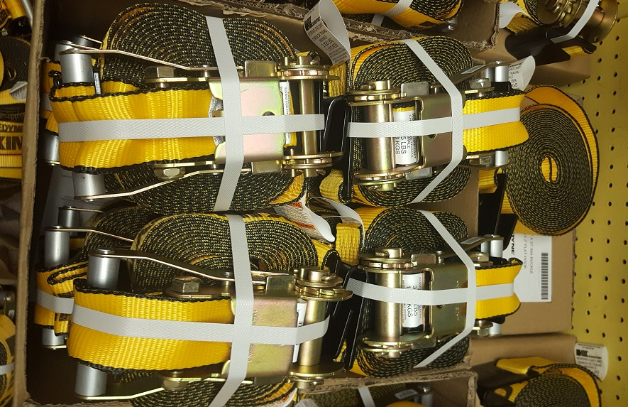 A bunch of yellow ratchet straps are stacked on top of each other