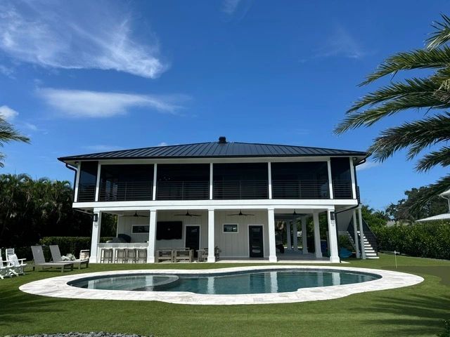 Modern two-story house with a pool and patio under a blue sky