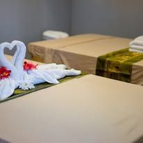 A couple of swans made out of towels on a table in a spa.