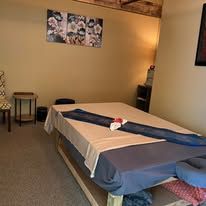 A massage table in a room with a table cloth on it.