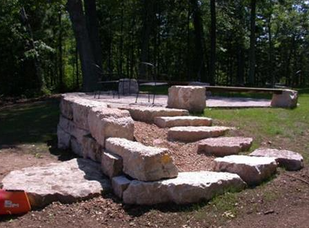 Stone outdoor steps and bench in a wooded park setting