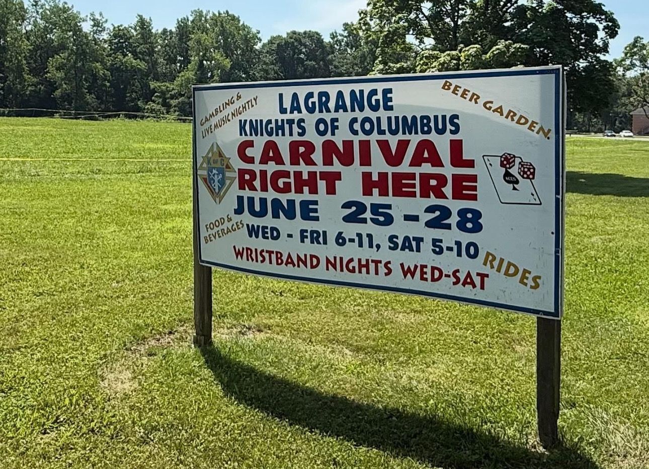 Sign for the LaGrange Knights of Columbus Carnival, June 25-28, with ride and wristband information.