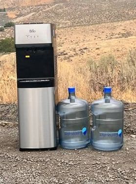 water cooler with extra bottles of water