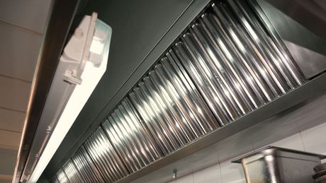 A kitchen hood with a light hanging from it