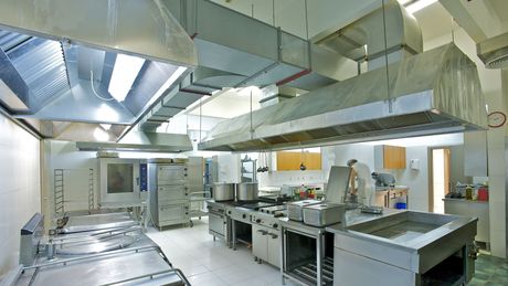 A large commercial kitchen with lots of stainless steel appliances