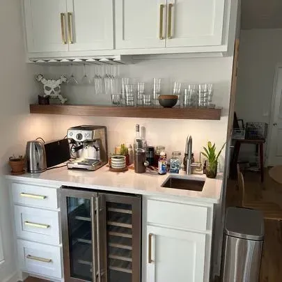 Home bar area with white cabinets, a wine fridge, and a built-in sink.