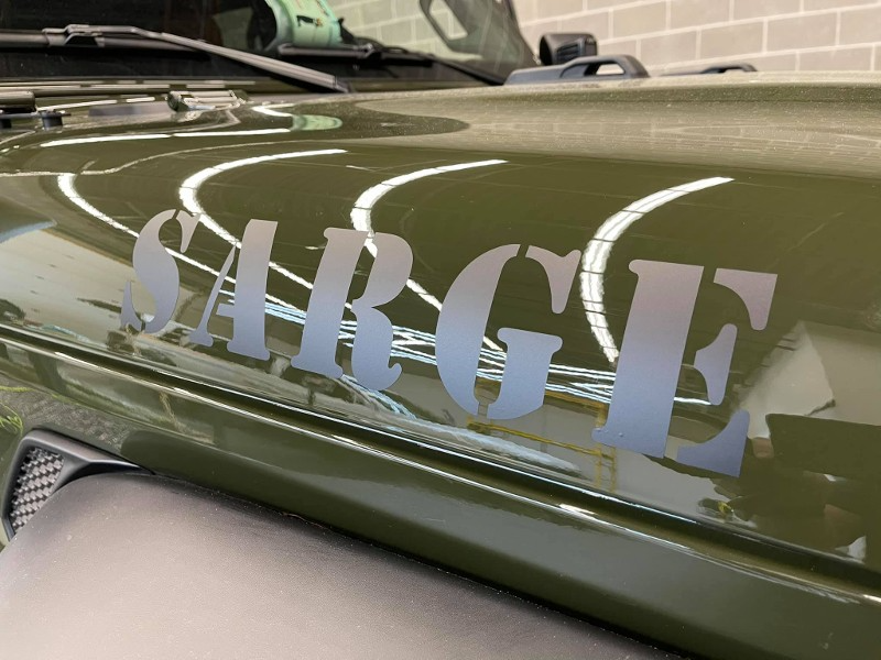 A green jeep with the word sage on the hood