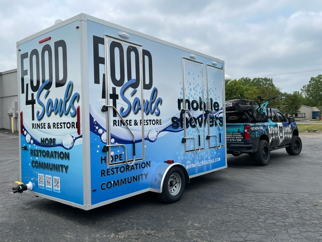 A food 4 souls trailer is being towed by a truck.