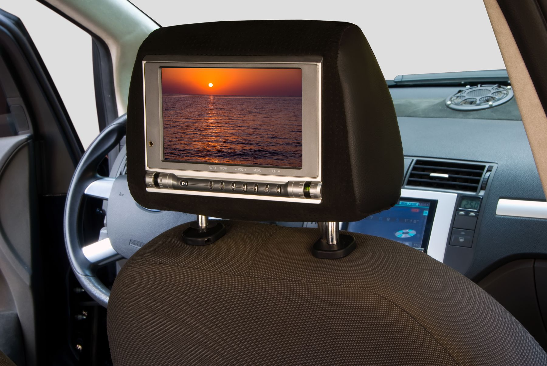 A headrest monitor in a car shows a picture of the ocean
