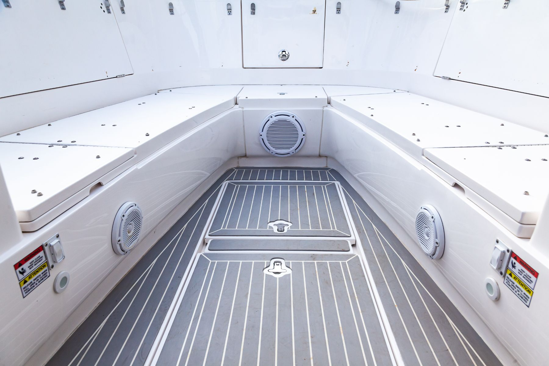 The inside of a boat with a gray and white striped floor