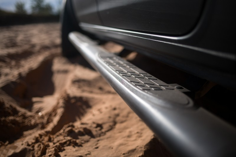 A close up of a car 's side step in the sand