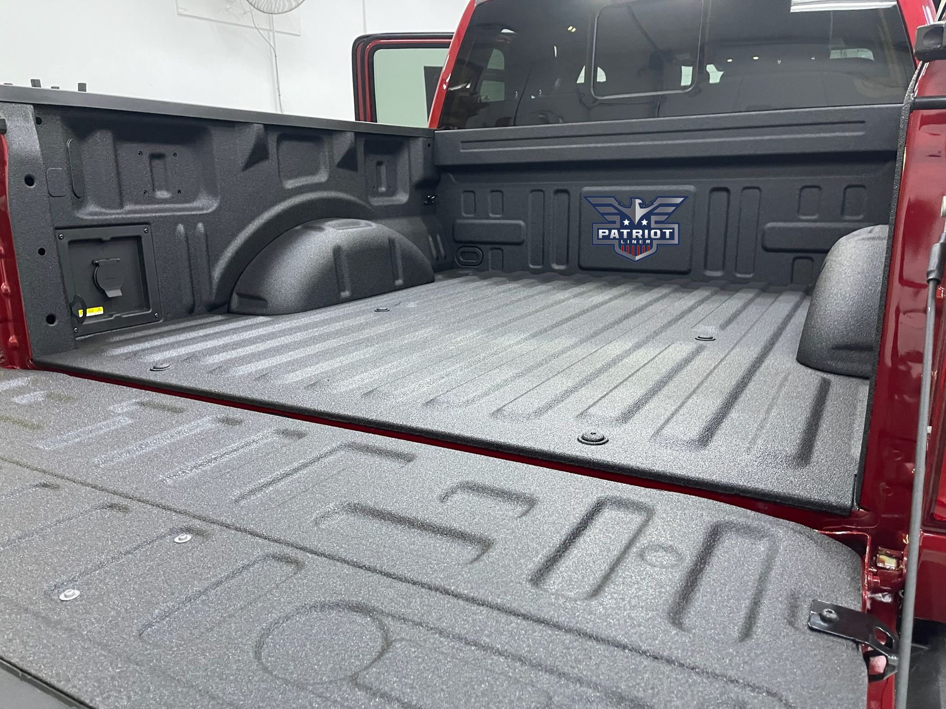 The back of a red truck with the bed open