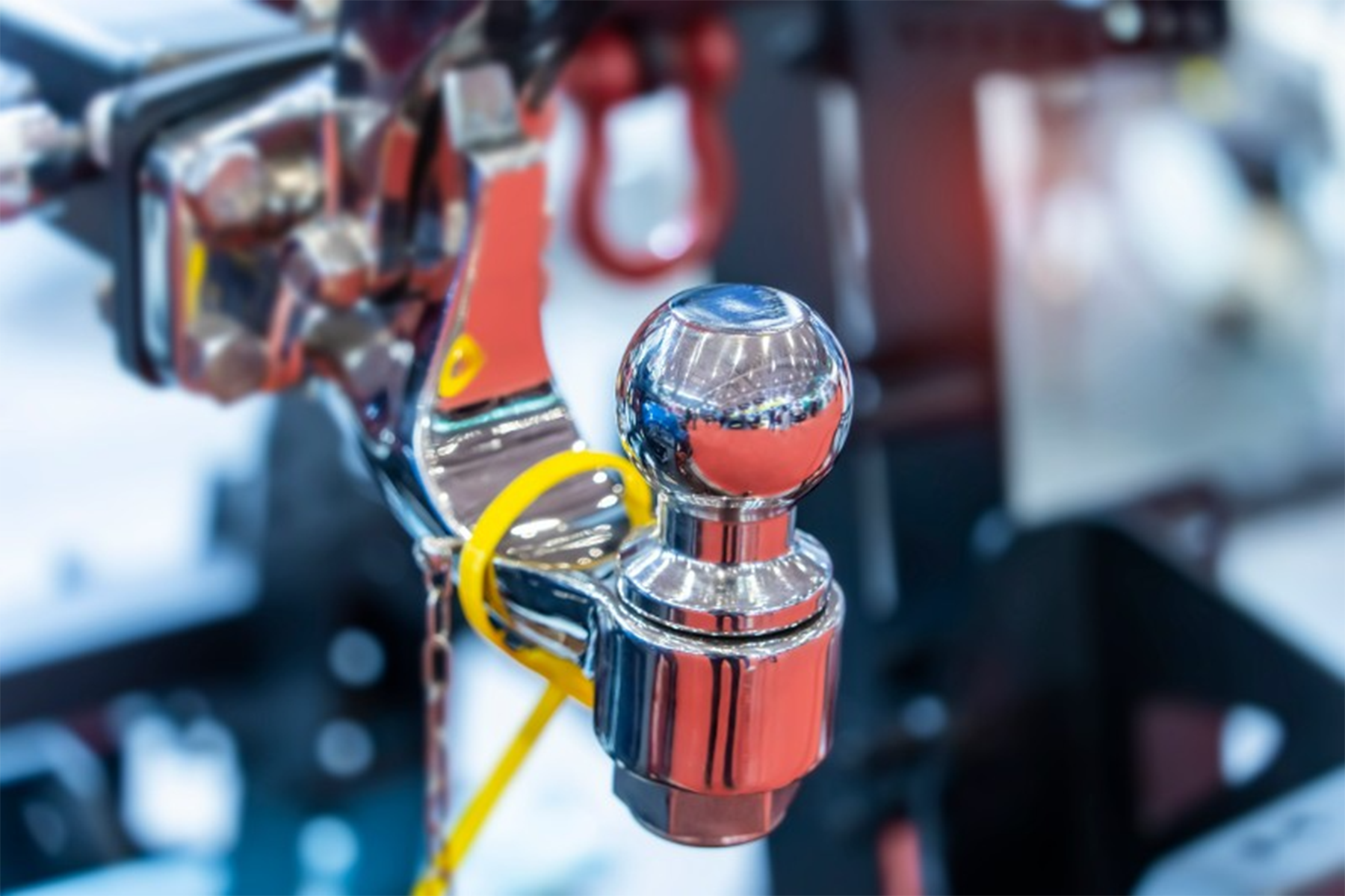 A close up of a trailer hitch with a yellow tag attached to it.