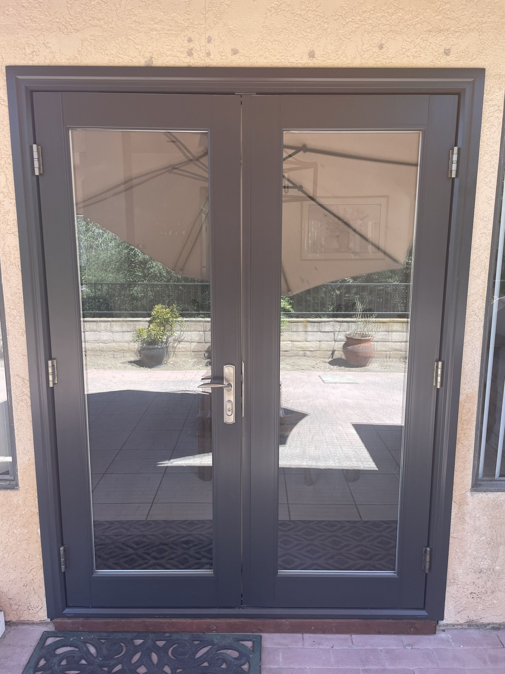 Black double glass doors with metal mesh on a building entrance